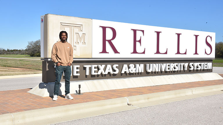Johnnie Armstrong in front of a RELLIS sign